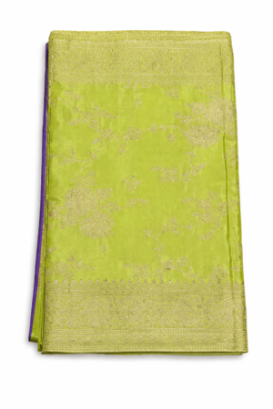 Radiant lime green Banarasi silk saree with intricate gold zari floral weaving, rich traditional border, and a bold contrast purple blouse piece for festive elegance.
