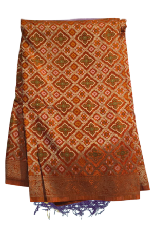 A luxurious burnt orange Bandhani saree featuring intricate allover zari jaal patterns and rich traditional weaving for a grand festive look.