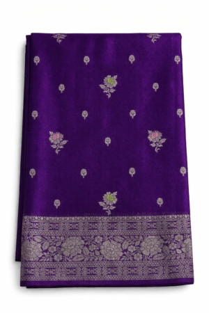 A regal royal purple Banarasi soft silk saree featuring delicate woven butis, an opulent floral zari border, and an intricately woven paisley pallu for timeless festive elegance.