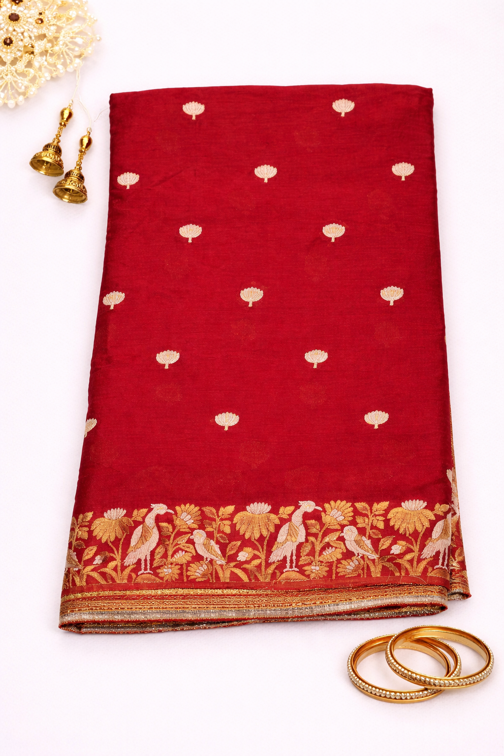 Stunning red Chinon silk saree adorned with elegant gold buti motifs and a richly woven traditional zari border for timeless festive charm.