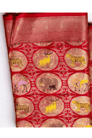 Striking red semi Gadwal saree featuring artistic wildlife-inspired motifs, intricate medallion design, and an elegant zari woven border.