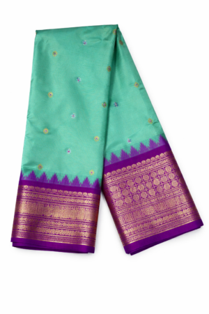 Elegant sea green semi Gadwal saree with delicate butis, a vibrant magenta contrast zari border, and a rich traditional woven pallu.