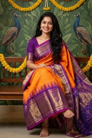 A timeless Pochampally Ikat silk orange saree with a rich purple zari border crafted for graceful festive elegance and traditional celebrations.