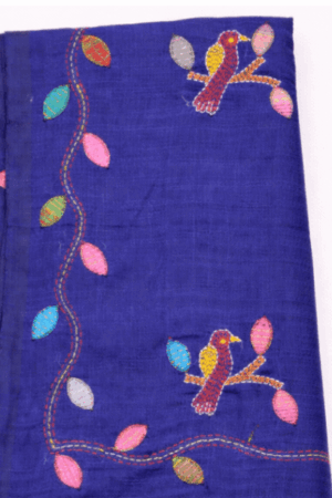 Elegant navy blue pure linen saree featuring colorful bird and leaf embroidery with handcrafted charm and soft tassel detailing.