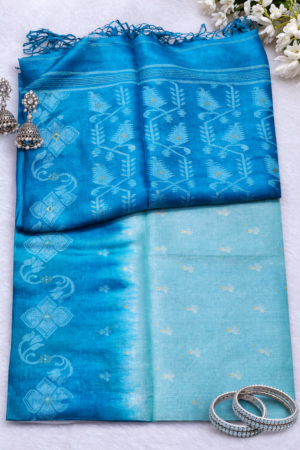 Elegant sky blue pure tussar saree featuring delicate Jamdani-inspired motifs, artistic woven pallu, and soft handcrafted tassels for graceful traditional charm.