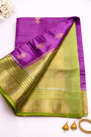 Elegant lavender purple raw mango silk saree featuring delicate floral zari motifs and a graceful olive green contrast woven border for a refined festive look.