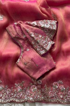 A dreamy blush pink organza saree adorned with rich floral sequins embroidery, scalloped embellished borders, and luxurious festive elegance.