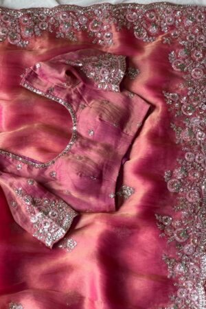 A dreamy blush pink organza saree adorned with rich floral sequins embroidery, scalloped embellished borders, and luxurious festive elegance.