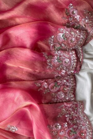 A dreamy blush pink organza saree adorned with rich floral sequins embroidery, scalloped embellished borders, and luxurious festive elegance.