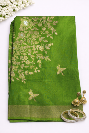 Graceful parrot green Russian silk saree featuring elegant floral vine weaving, artistic bird motifs, and a rich zari border for a luxurious festive look.