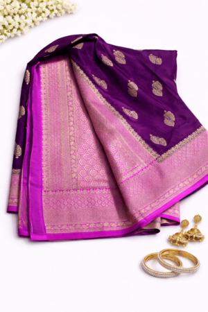 Elegant royal purple Russian silk saree featuring silver buti motifs, a rich contrast pink woven pallu, and a graceful festive finish.