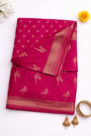 Vibrant rani pink soft silk saree featuring elegant gold bird motifs, delicate buti detailing, and a rich woven zari border for a graceful festive statement.
